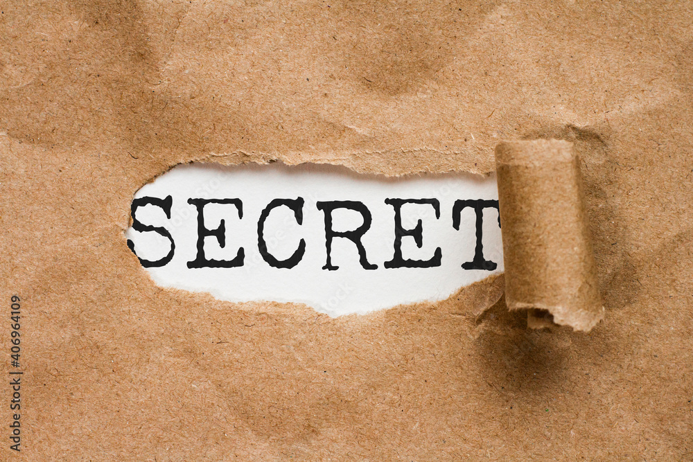 Secret. the word secret appears in a hole in a folder の Stock 