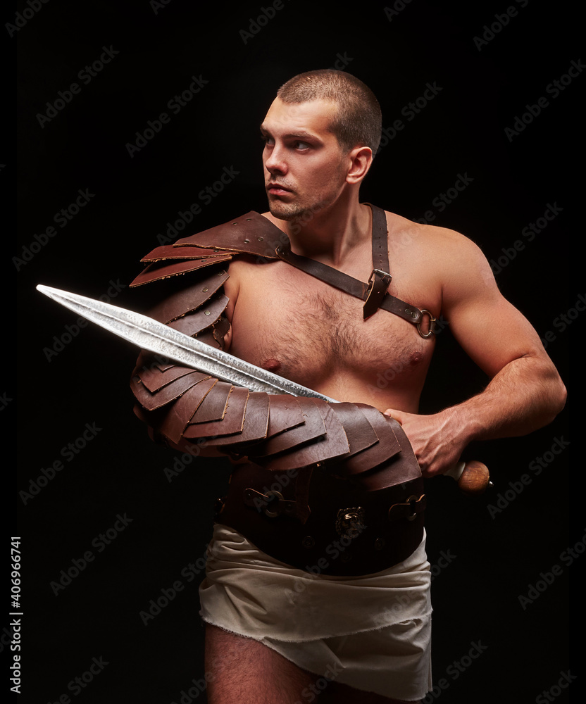 Gladiator with sword and armor on a black background. A warrior in ...