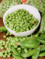 Poster - fresh green pea in bowl on wooden background