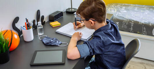 Wall Mural - Teenager doing homework at the desk in his room