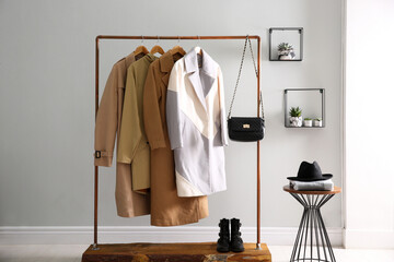 Wall Mural - Different warm coats on rack in stylish room interior