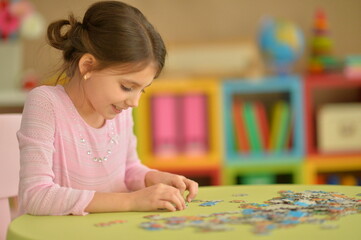 Wall Mural - Cute little girl collecting puzzle pieces