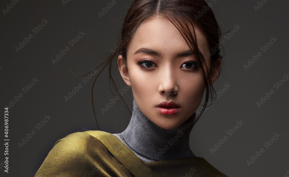 Beautiful Asian woman in a green shawl. Beauty of mysterious Chinese girl with flowing hair. Fashion, clothing and cosmetics - obrazy, fototapety, plakaty 