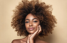 Beauty Portrait Of African American Woman With Clean Healthy Skin On Beige Background. Smiling Beautiful Afro Girl.Curly Black Hair. Black Teen Girl