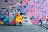 Fototapeta Młodzieżowe - Street artist painting colorful graffiti on wall