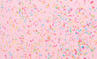 Leinwandbild Motiv rainbow sprinkles on pink background
