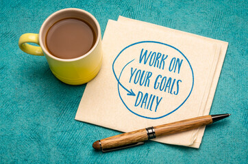 work on your goals daily - motivational reminder, handwriting on a napkin with a cup of coffee, goal setting, business and personal development concept