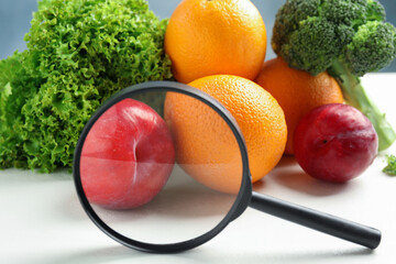 Wall Mural - fresh fruits, vegetables and magnifying glass on white table, closeup. poison detection