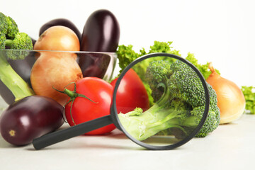 Wall Mural - different fresh vegetables and magnifying glass on table, closeup. poison detection