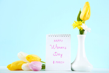 Wall Mural - Text Happy Womens Day with tulip flowers on blue background