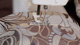 Fototapeta Paryż - process of sewing curtains on the sewing machine. Sewing foot and needle close-up.