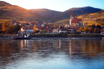 Wall Mural - autumn view of small austrian village on a river bank