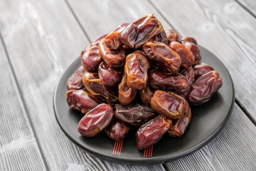 Close-up of red raw organic dates, a pile on a saucer. Healthy eating. Organic food. Delicious food. The natural background.