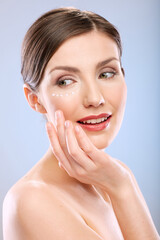 Wall Mural - Beauty portrait of smiling woman with moisturizer on face.