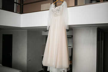 The wedding dress is hanging in the house.