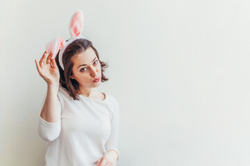 Wall Mural - Happy Easter holiday celebration spring concept. Young woman wearing bunny ears isolated on white background. Preparation for holiday. Girl looking happy and excited having fun on Easter day