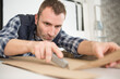 © auremar - workman cutting cardboard with a craft knife