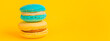 Sweet almond colorful unicorn blue yellow macaron or macaroon dessert cake isolated on trendy yellow modern fashion background. French sweet cookie. Minimal food bakery concept Copy space