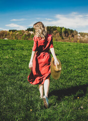 Sticker - Beautiful girl in red dress and hat have a carefree time on meadow