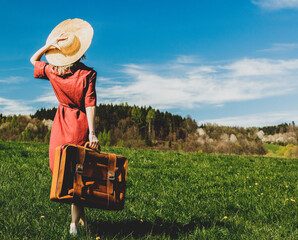 Sticker - Beautiful girl in red dress and hat with suitcase on meadow