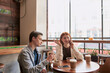 © Svitlana - Two teenagers spending time together, sitting in a cafe on a daytime. Guy looking bored, eating his meal while his girlfriend is ignoring him, talking on the phone