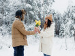 © Tatsiana - A young guy gives a bouquet of yellow tulips to a girl in a snowy forest. Valentine's Day.