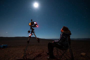 Wall Mural - one astronomer man looking the night sky through an amateur telescope and taking photos to the chris