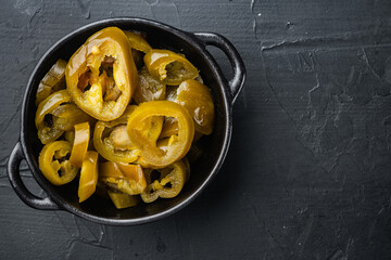 Jalapenos pickled and sliced, on black background, top view flat lay with copy space for text