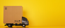 Big Cardboard Box Package On A Grey Truck Ready To Be Delivered On Yellow Background