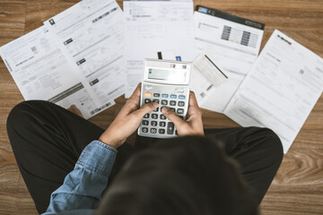 top view man sitting on the floor stressed and confused by calculate expense from invoice or bill, h
