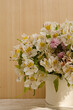Arreglo floral con diferentes tipos de flores sobre una mesa y un fondo de madera. Concepto decoración para eventos sociales