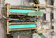 Demarcation point tag to mark the point where the public and private telecommunication network connect. Demarc rack with punch-down blocks and wiring in service room. Selective focus on tag.