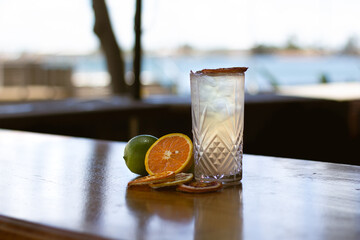 Summer Fresh Fruity Cocktail on table in front of water with fresh fruit. Great on it's own, for social media or for a poster.