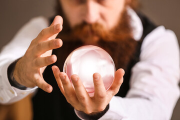 Wall Mural - Male fortune teller with crystal ball reading future, closeup