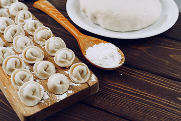 Raw stuffed russian dumplings on wooden board