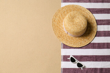 Sticker - Straw hat, sunglasses, towel and space for text on beach sand, top view. Summer vacation