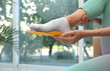 Woman fitting orthopedic insole indoors, closeup. Foot care