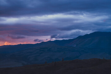 Wall Mural - atmospheric landscape with silhouettes of mountains on background of vivid dawn sky. colorful nature