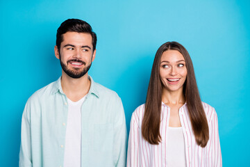 Poster - Photo of happy charming man and woman look each other wear striped shirt isolated on blue color background