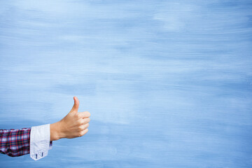 Wall Mural - Girl showing hand with thumbs up gesture on clean painted background