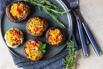 Wall Mural - Baked stuffed portobello mushrooms with bulgur pilaf and chopped vegetables. Delicious and nutritious vegetarian dish. Stone background.