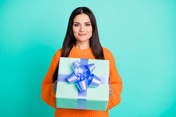 Sticker - Photo of cheerful lady give you decorated giftbox wear orange sweater isolated teal color background