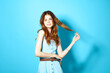 © SHOTPRIME STUDIO - pretty woman in blue dress holding her hair glamor attractive look blue background