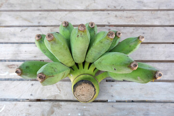 Wall Mural - green banana on wood background close up