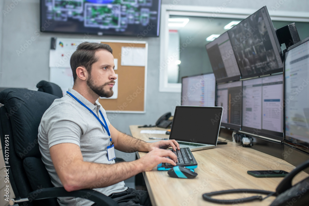 Man looking at computer screens sitting at keyboard Stock Photo | Adobe ...