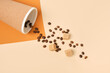Thermo mug, scattered coffee beans and brown cane sugar cubes on brown and beige geometric background