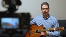 Man With Spanish Guitar In Front Of The Video Camera.