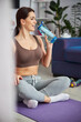 © Viacheslav Yakobchuk - Happy pretty woman drinking water after home workout