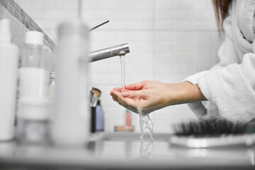 Wall Mural - Female using cosmetics face cream in bathroom