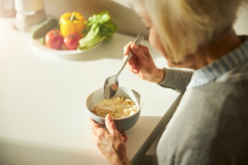 Blonde Caucasian woman having breakfast in the kitchen